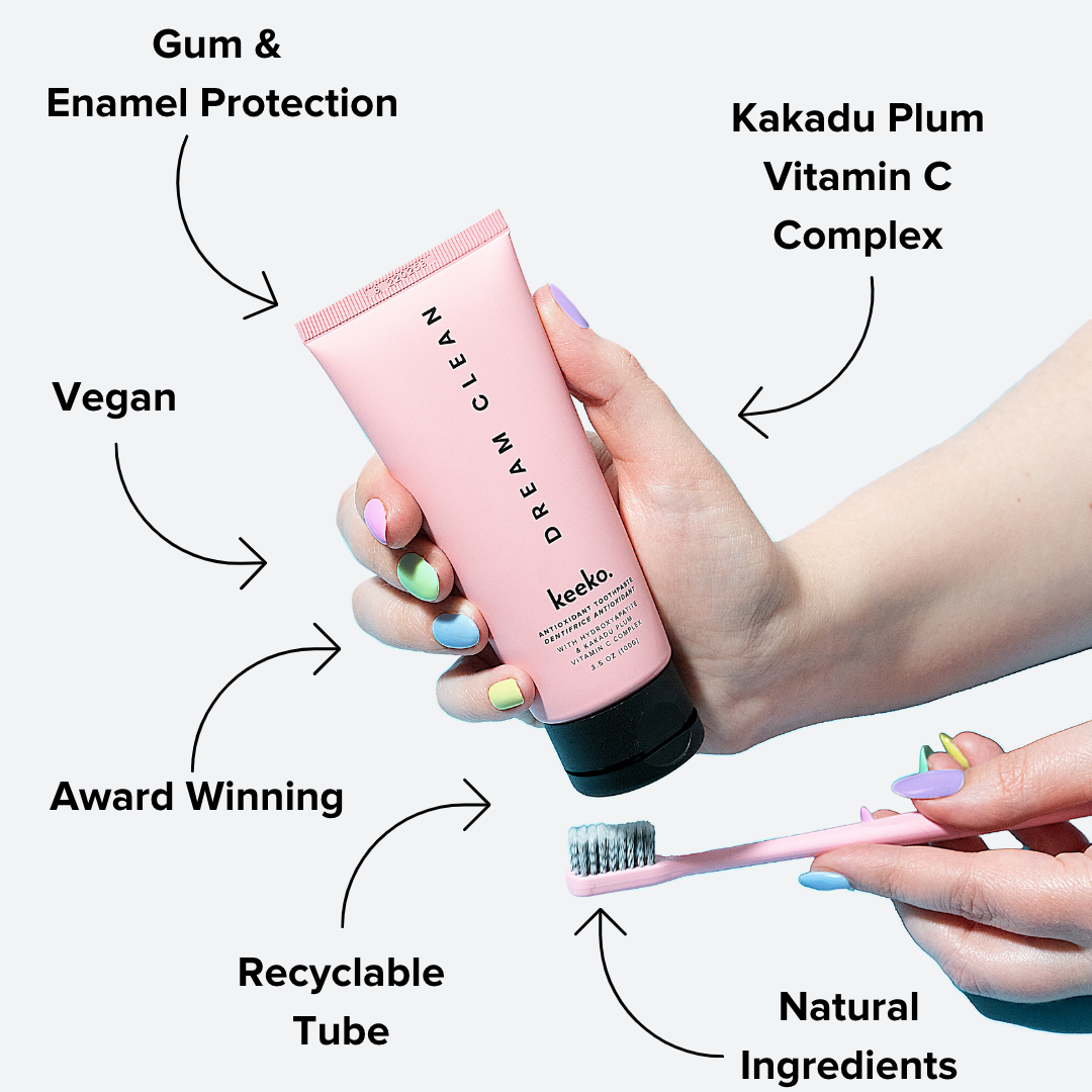 Dream Clean Toothpaste held by hand with a toothbrush, highlighting recyclable packaging and natural benefits.