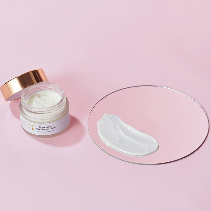 Open jar of Rejuvenating Anti-Wrinkle Cream 50ml with cream texture swatched on a mirror, showcasing its smooth and hydrating formula.