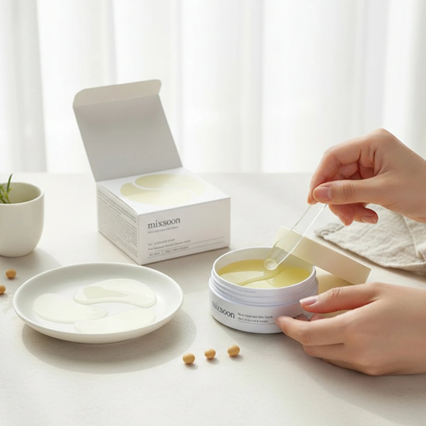 Hand lifting Mixsoon Bean Hydrogel Eye Patch from jar during skincare application