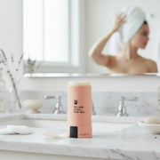 Papermoon unscented clean deodorant on bathroom counter with mirror and towel background