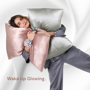 Model cuddling pink and grey silk pillowcases in sleepwear