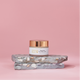 Rejuvenating Anti-Wrinkle Cream 50ml placed on stacked stone against a pink background, ideal for sensitive and aging skin.